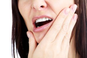 Woman holding her jaw in pain