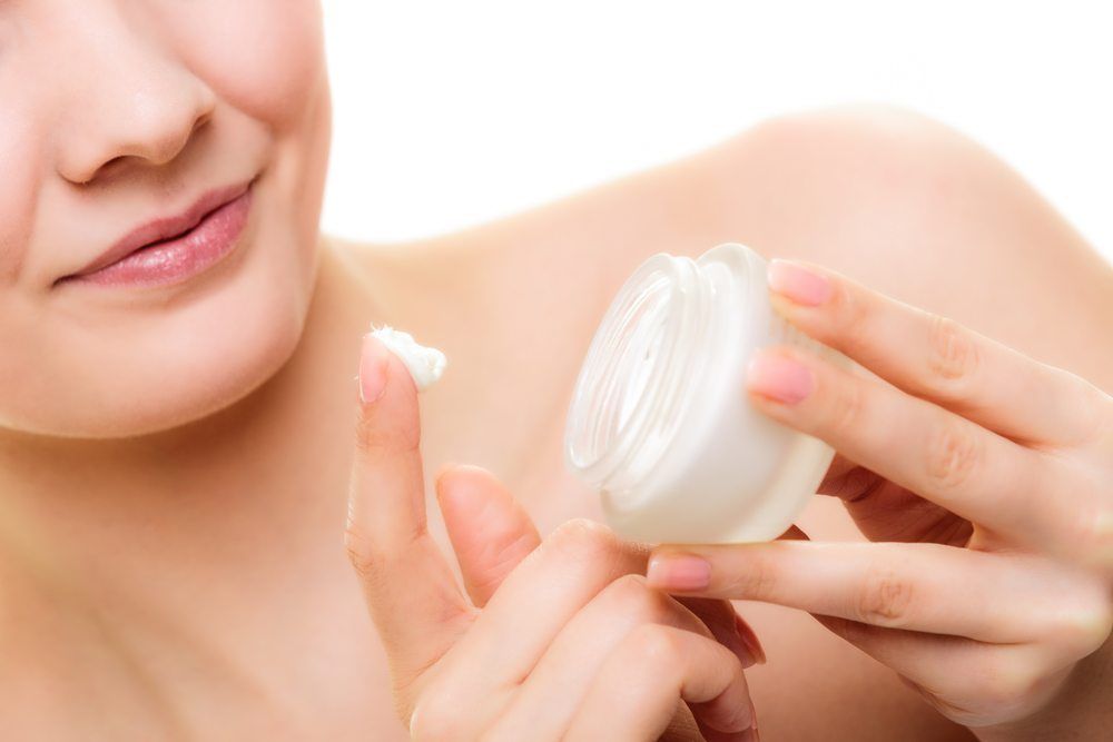 Woman treating her dry skin with moisturizer