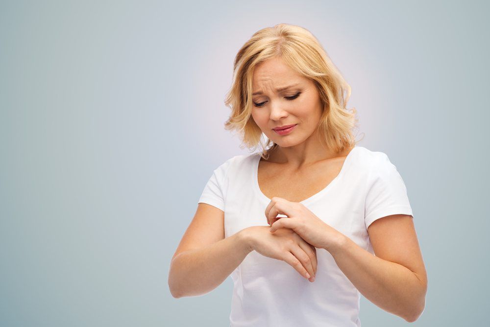 Distraught woman scratching her hand